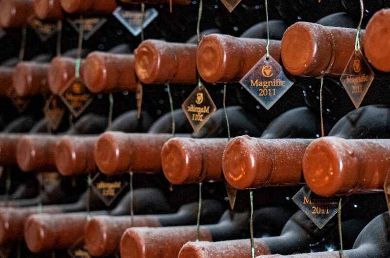 rows of vintage 2011 wine bottles stored horizontally in a dimly lit cellar